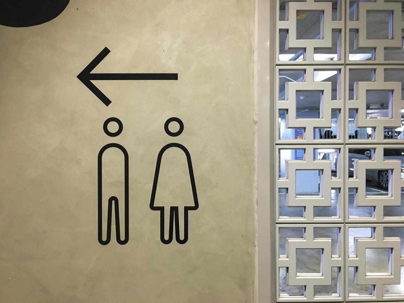 ein Schild, das den Weg zum Badezimmer in einem Einkaufszentrum weist. foto