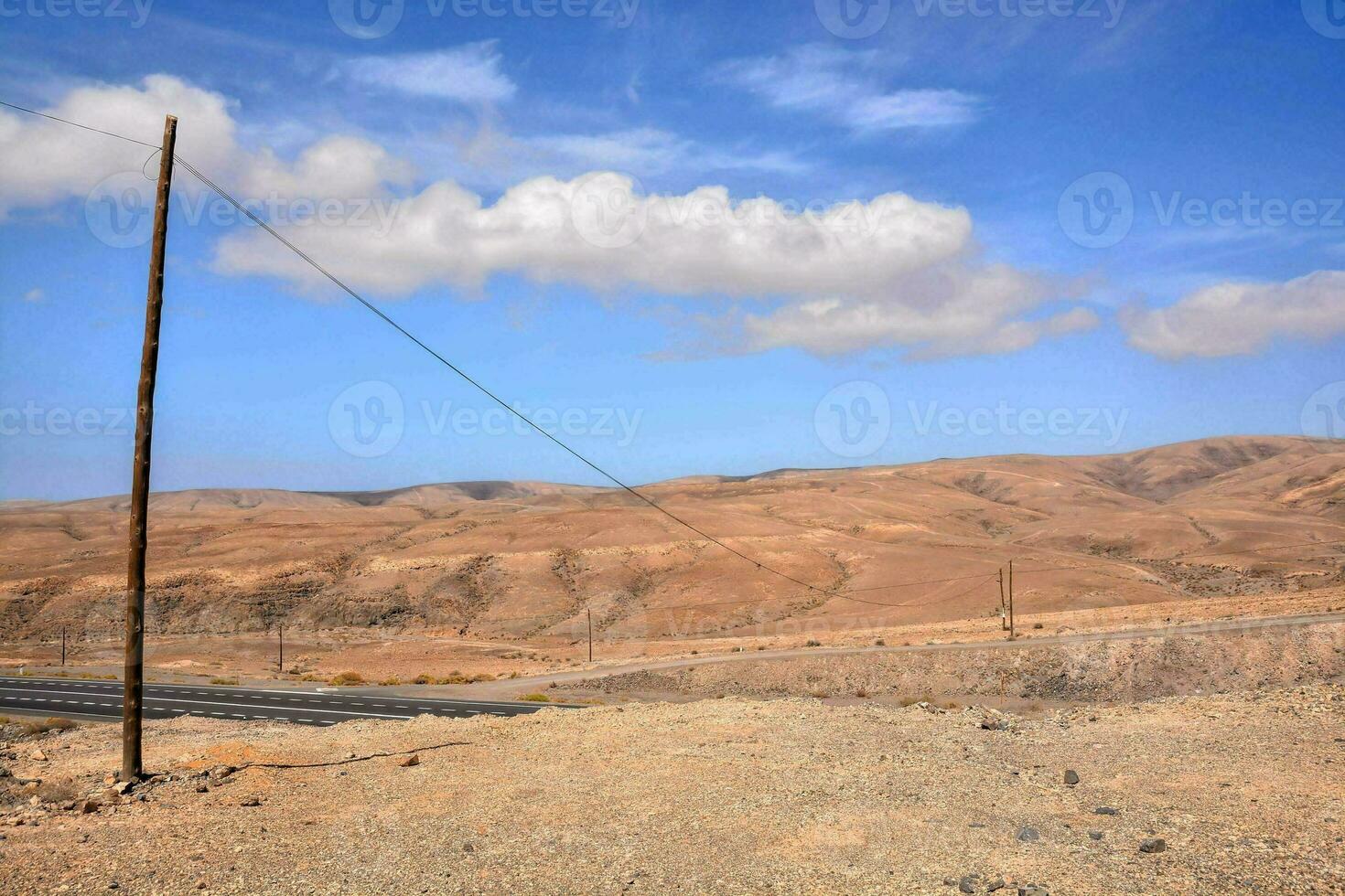 ein Telefon Pole im das Wüste mit Berge im das Hintergrund foto