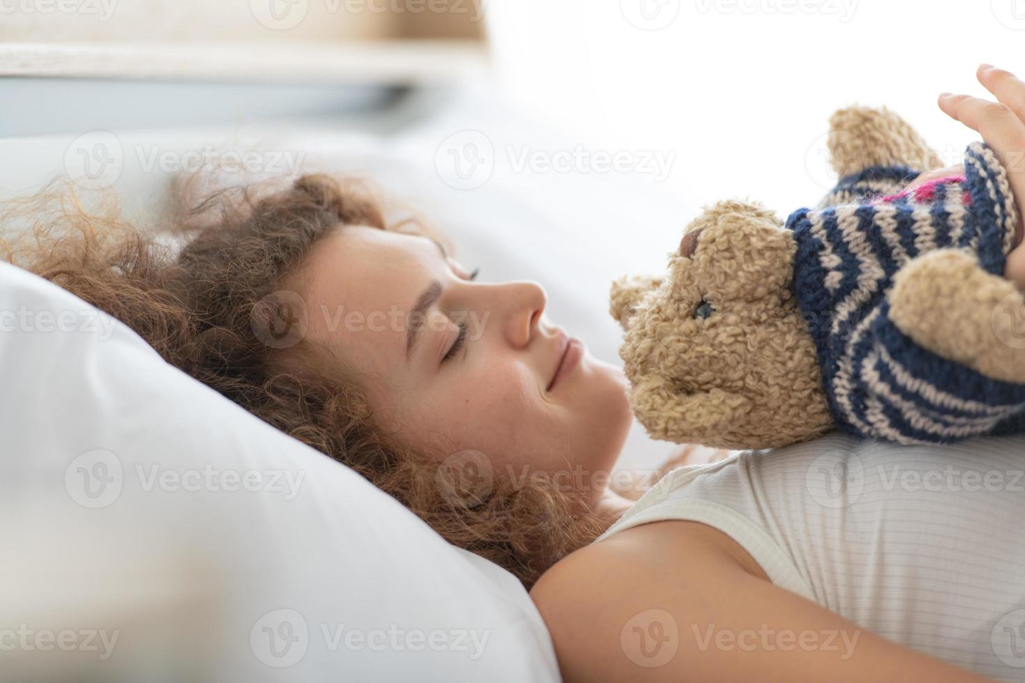 Frau entspannt sich im weißen Schlafzimmer der Wohnung foto