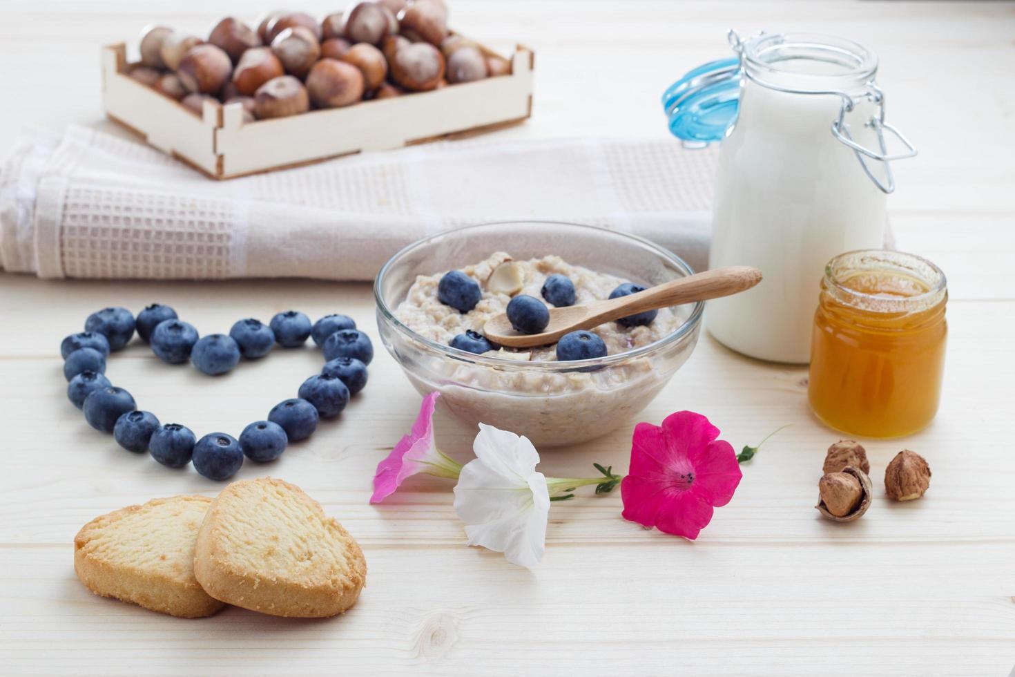 Liebesfrühstück aus Haferflocken Blaubeeren mit Herzen, Honig foto