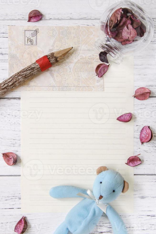 Papier mit Blütenblättern, Bleistift und Spielzeug foto