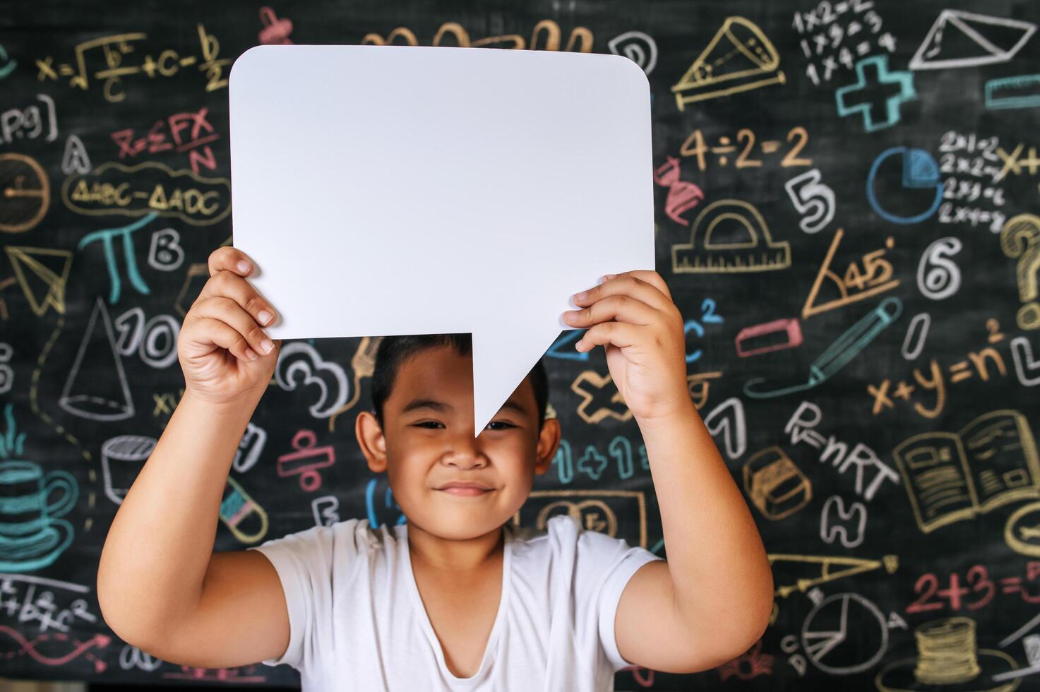 Kind spielt mit Sprechblase im Klassenzimmer foto