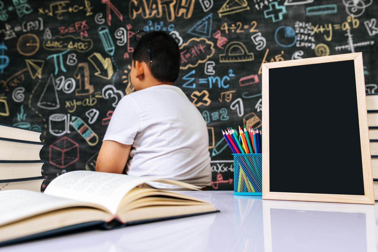 Kind sitzt mit dem Rücken im Klassenzimmer foto