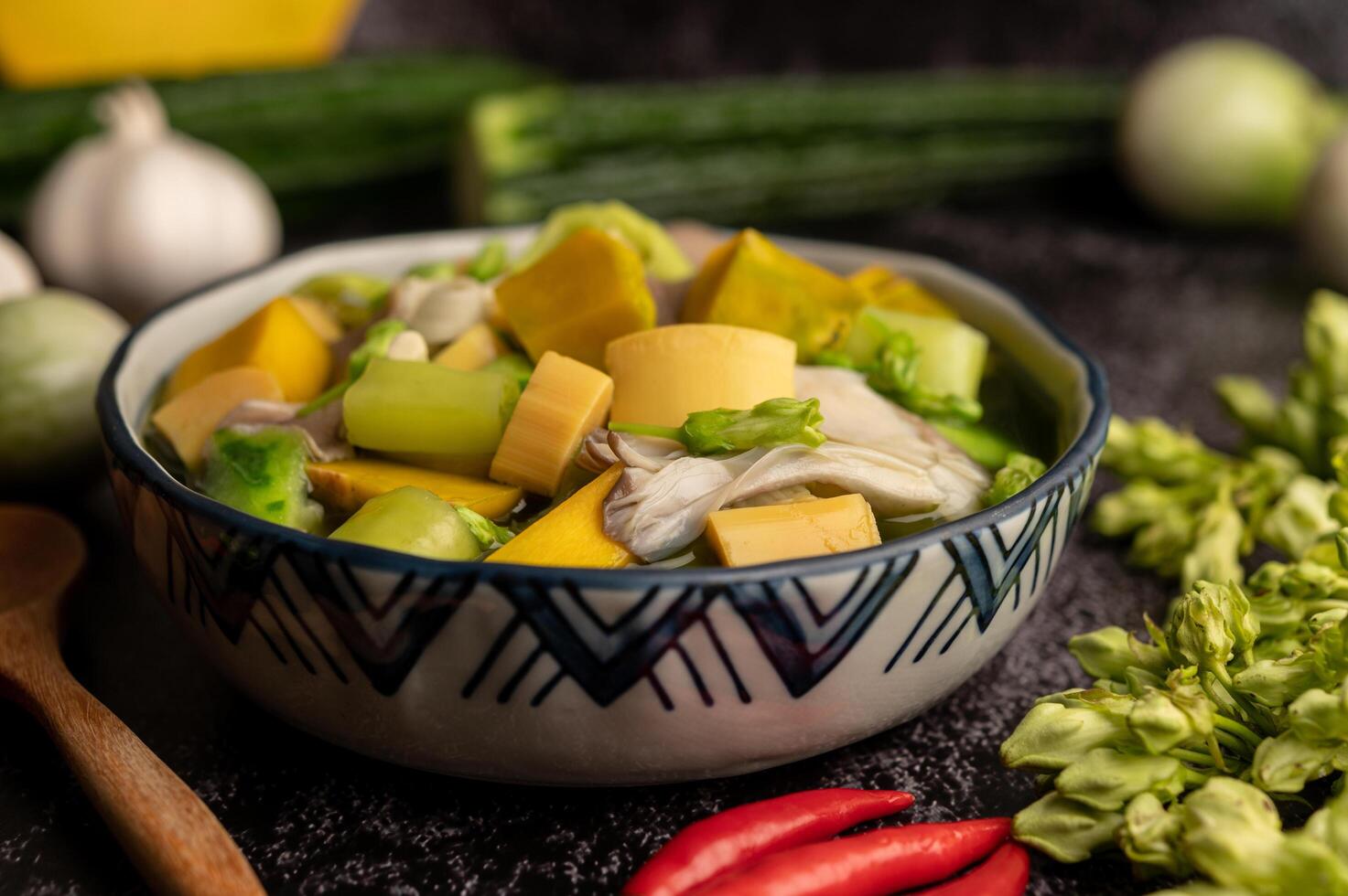 Kaeng Liang in einer Schüssel mit Gewürzen auf einem schwarzen Zementboden. foto