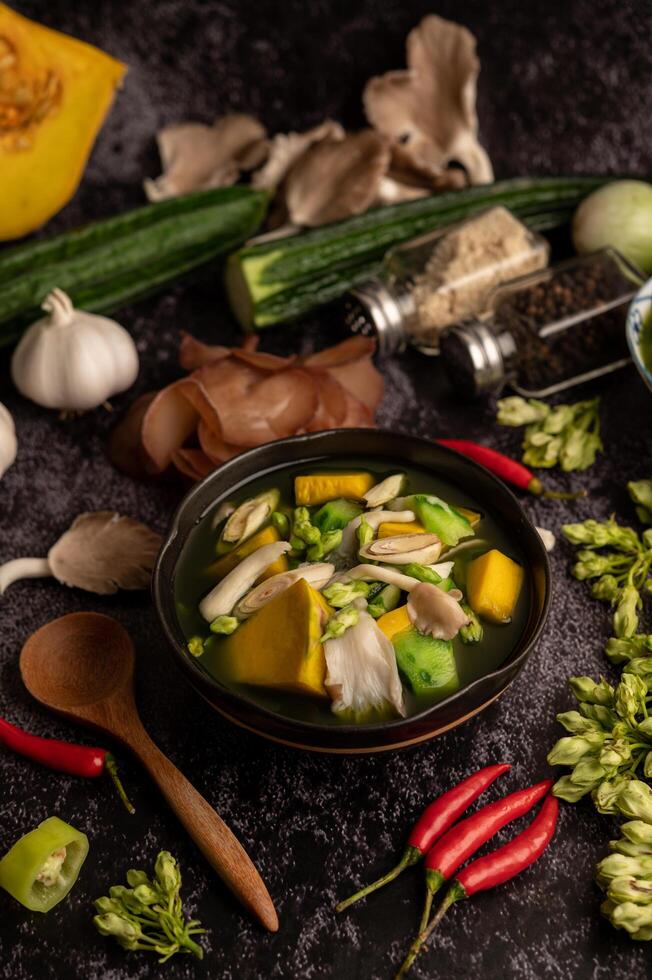 Kaeng Liang in einer Schüssel mit Gewürzen auf einem schwarzen Zementboden. foto