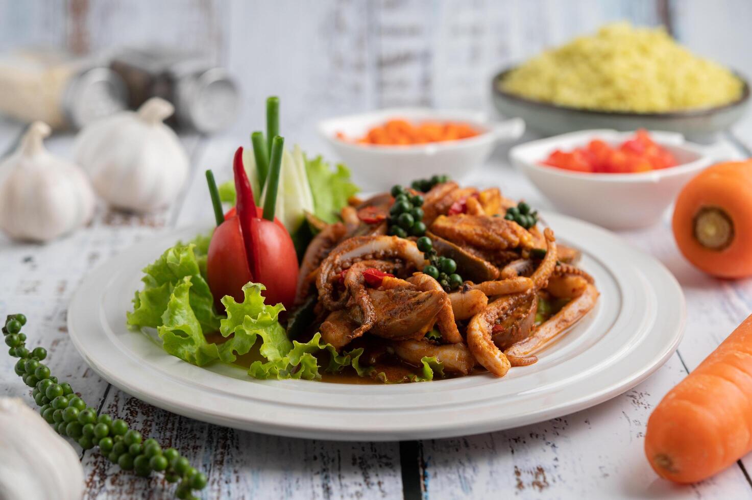 Gebratener Tintenfisch mit Currypaste in weißem Teller. foto