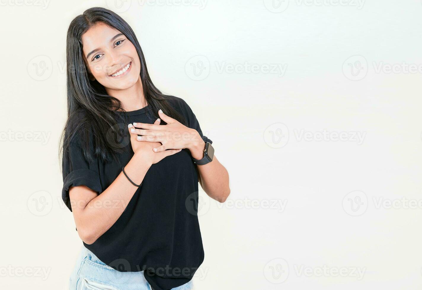dankbar Teenager Mädchen lächelnd mit Hände auf Truhe isoliert. positiv Latein Mädchen mit Hände auf Brust. dankbar Menschen mit Hände auf Herz foto