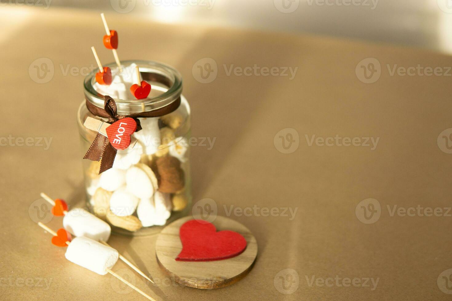 Süss Geschenk zum Valentinstag Tag mit Ihre besitzen Hände. ein Geschenk zum das Urlaub gemacht von herzförmig Süßigkeiten und Marshmallows foto