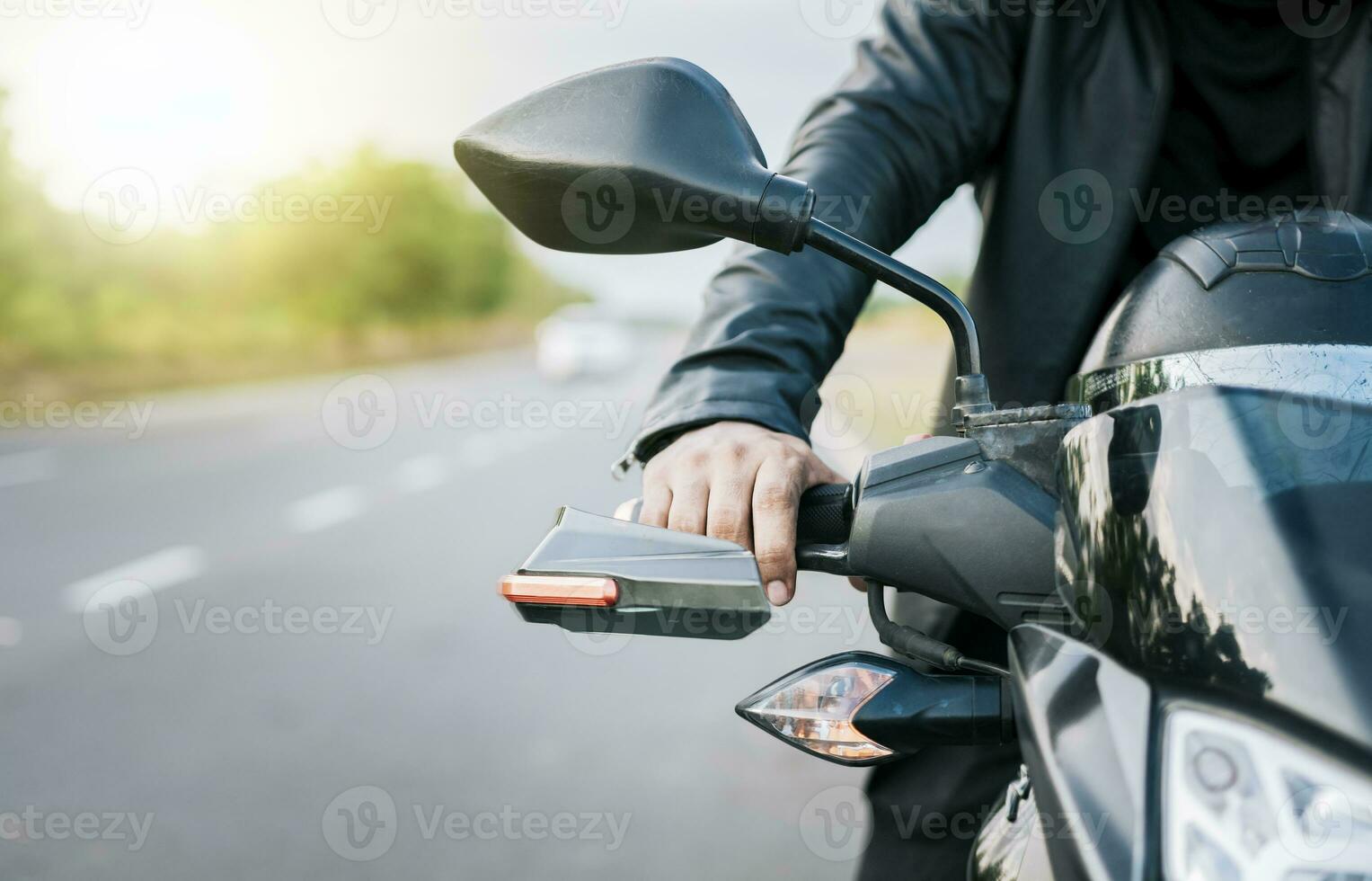 schließen oben von Hände von Biker auf das Lenker von ein Motorrad draußen. Hände von ein Motorradfahrer auf das Lenker auf das Straße. Motorrad Beschleunigen Konzept foto