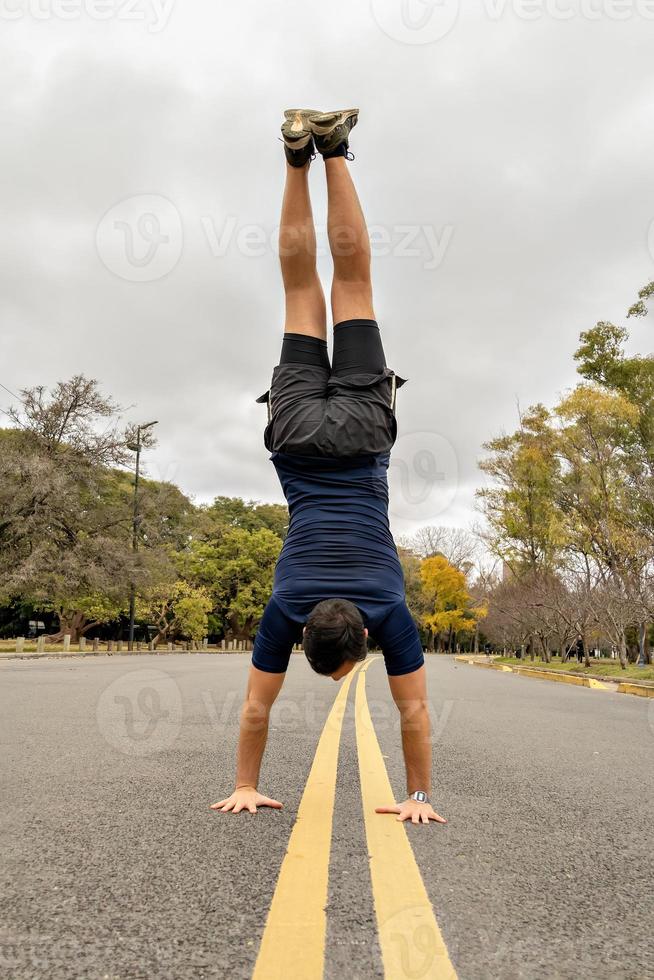 Mann macht einen Handstand mitten auf der Straße foto