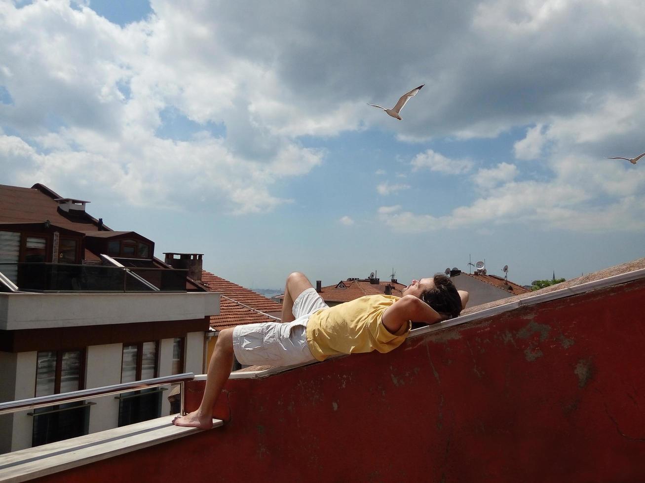 Person, die sich am Sommertag auf dem Dach entspannt foto