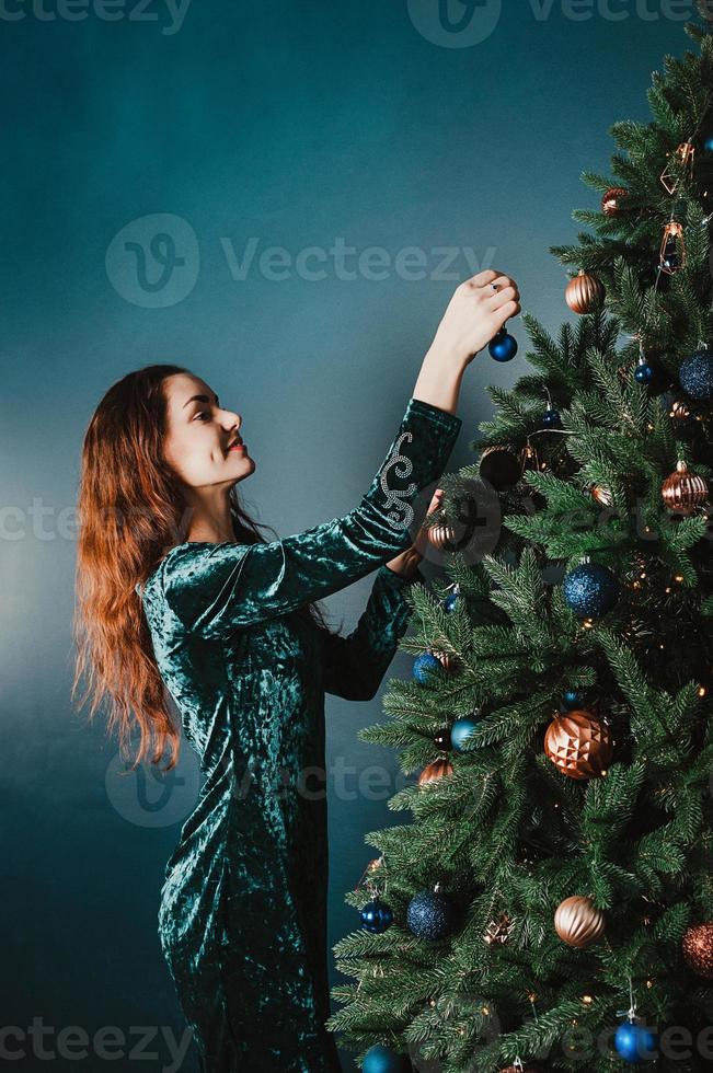 attraktive lächelnde frau, die weihnachtsbaum schmückt foto