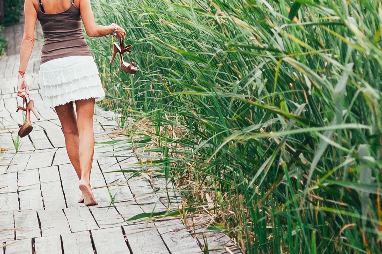 schlankes barfüßiges Mädchen, High Heels in den Händen, weggehen foto