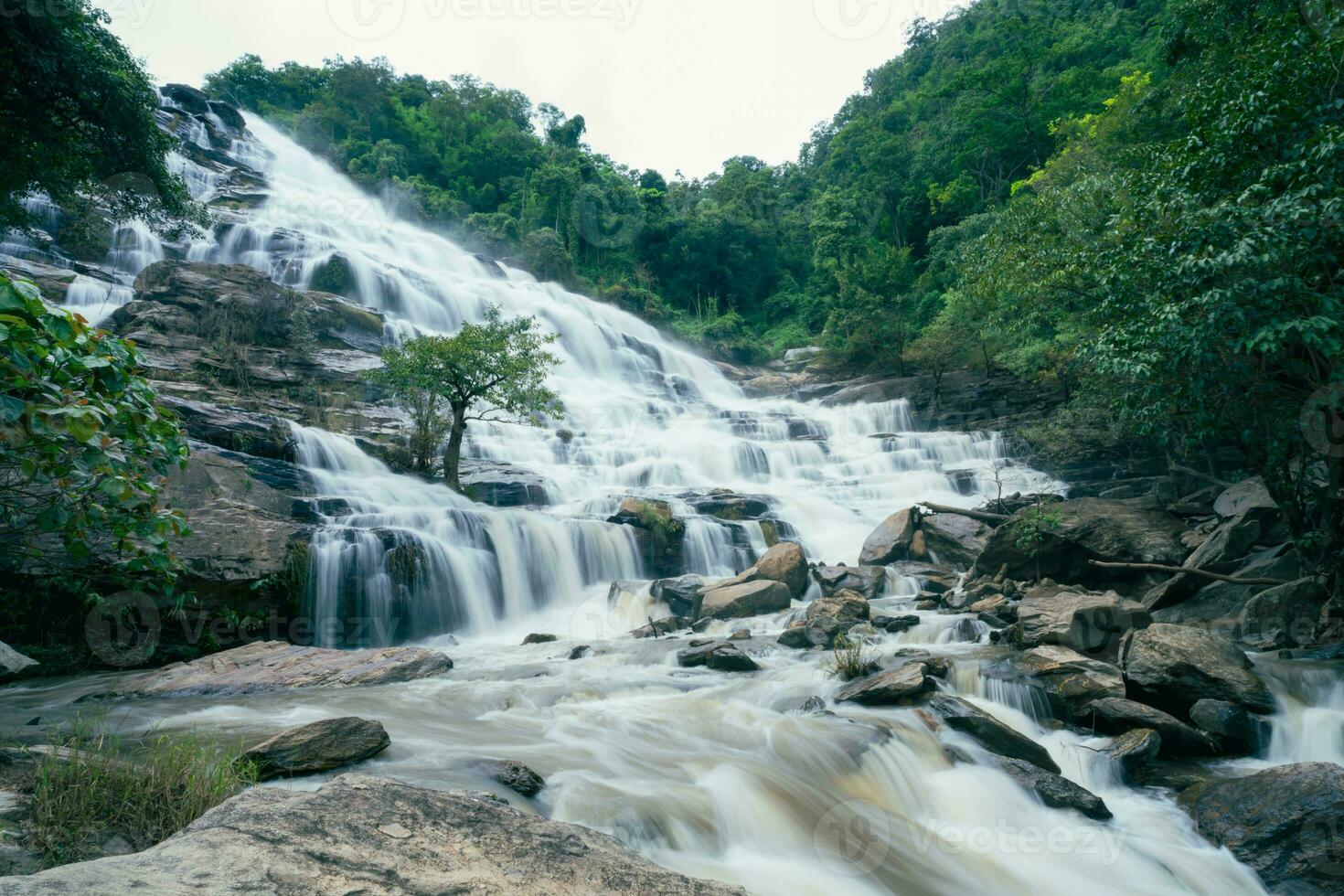 schön Wasserfall im üppig tropisch Grün Wald. Natur Landschaft. mae ya Wasserfall ist gelegen im doi inthanon National Park, Chiang Mai, Thailand. Wasserfall fließt durch Urwald auf Berghang. foto