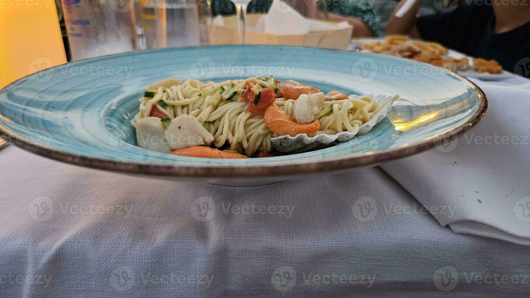 Italienisch Spaghetti mit ein Fisch Soße Dressing auf ein Teller beim ein Meeresfrüchte Restaurant foto