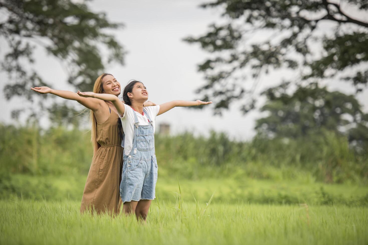 Mutter und Tochter stehen glücklich auf der Wiese foto