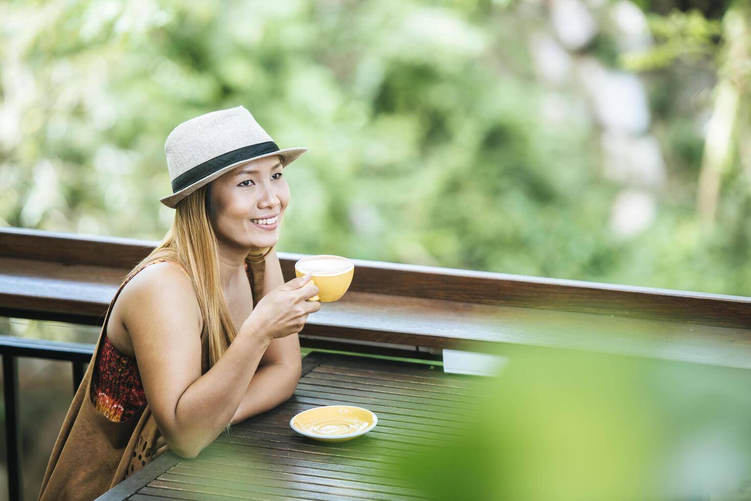 glückliche junge Frau mit Latte-Kaffee am Morgen foto