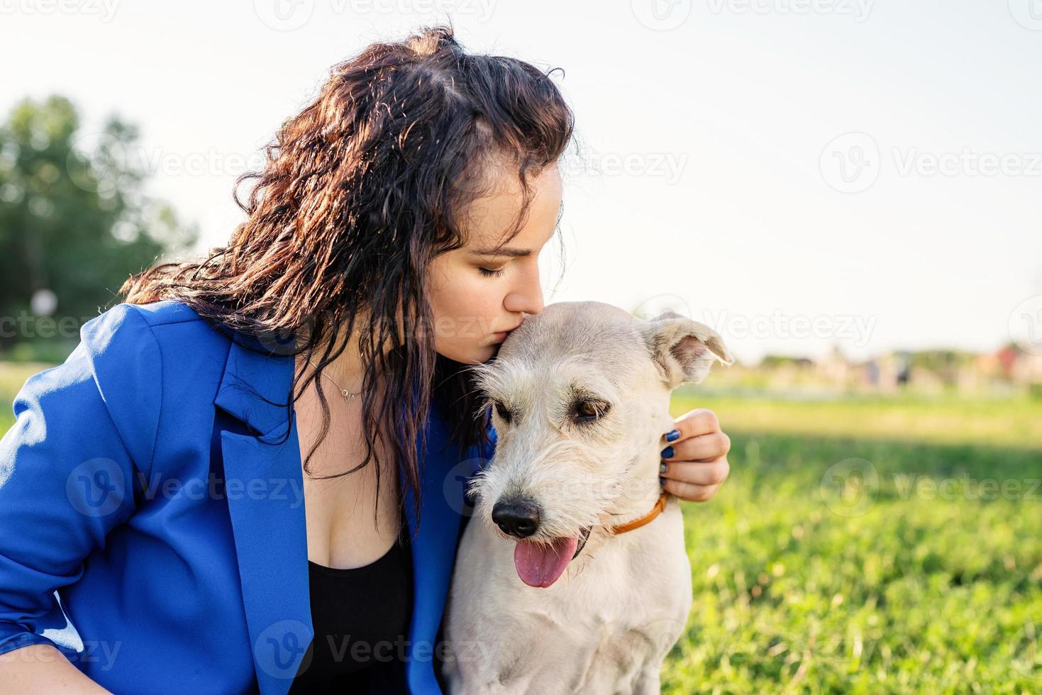 junge attraktive Frau, die ihren Hund küsst foto