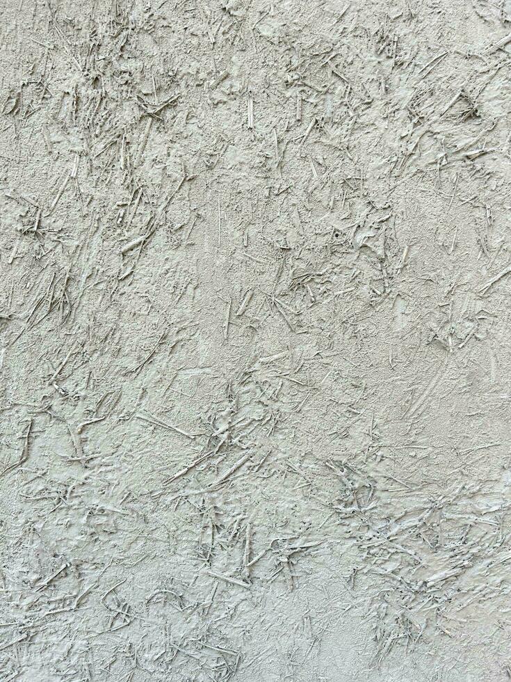 Weiß Mauer ist gemalt mit Heu und Reis Stroh. Mauer gemalt mit Weiß malen. abstrakt Hintergrund mit alt Weiß Gips. grau Farbe. Vertikale Komposition. texturiert grau Hintergrund. foto
