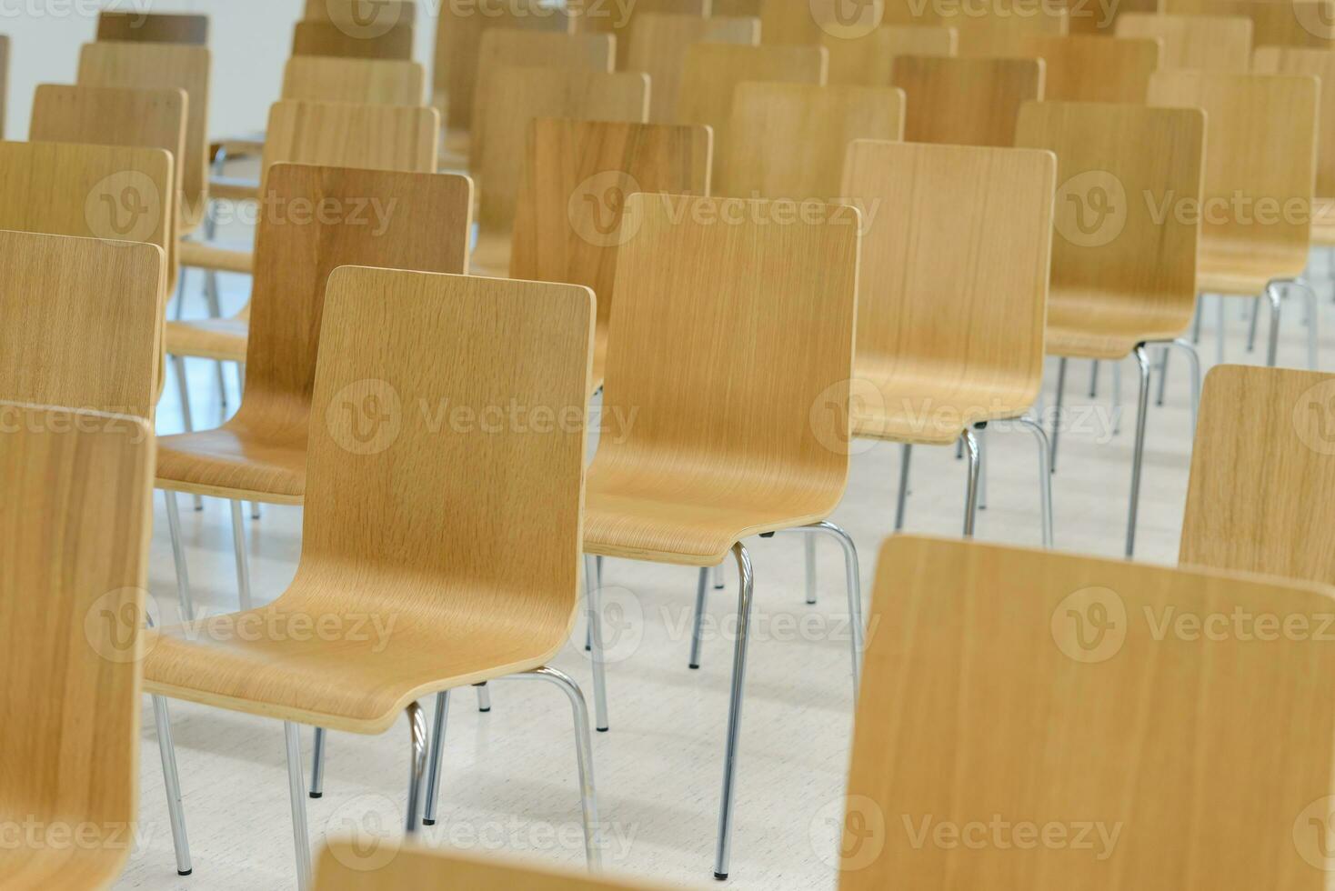 viele leeren hölzern Stühle einstellen ordentlich Reihen im Konferenz Zimmer foto