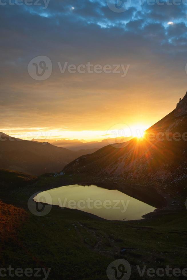 Sonnenaufgang am kleinen Bergsee in den Alpen foto