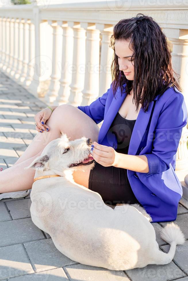 junge Frau spielt mit ihrem Hund im Park foto