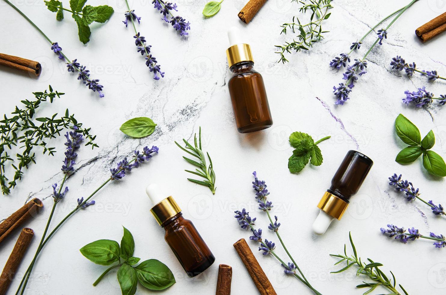 Flaschen ätherischer Öle mit Kräutern und Blumen foto