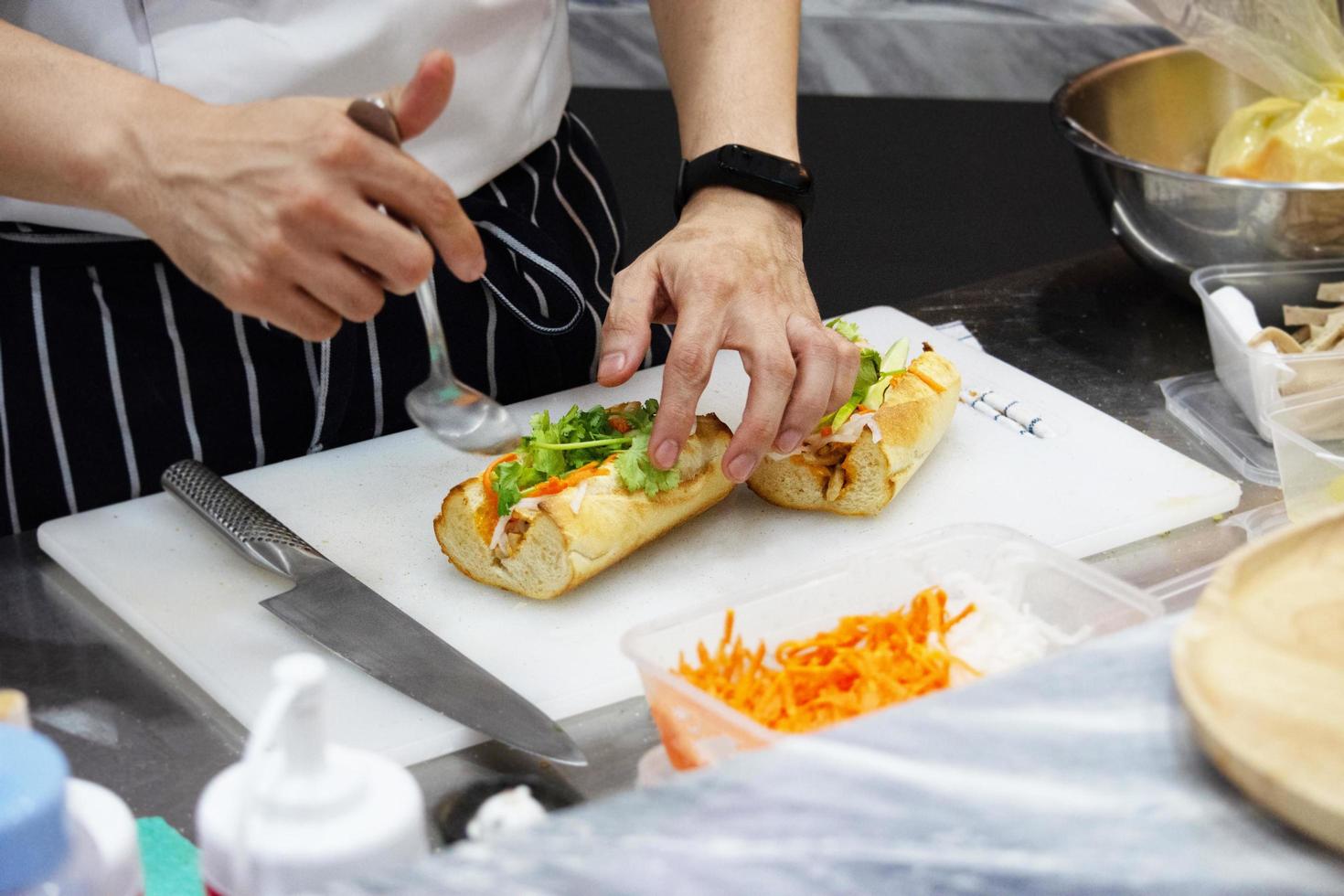 Koch bereitet Sandwich in der Küche zu foto