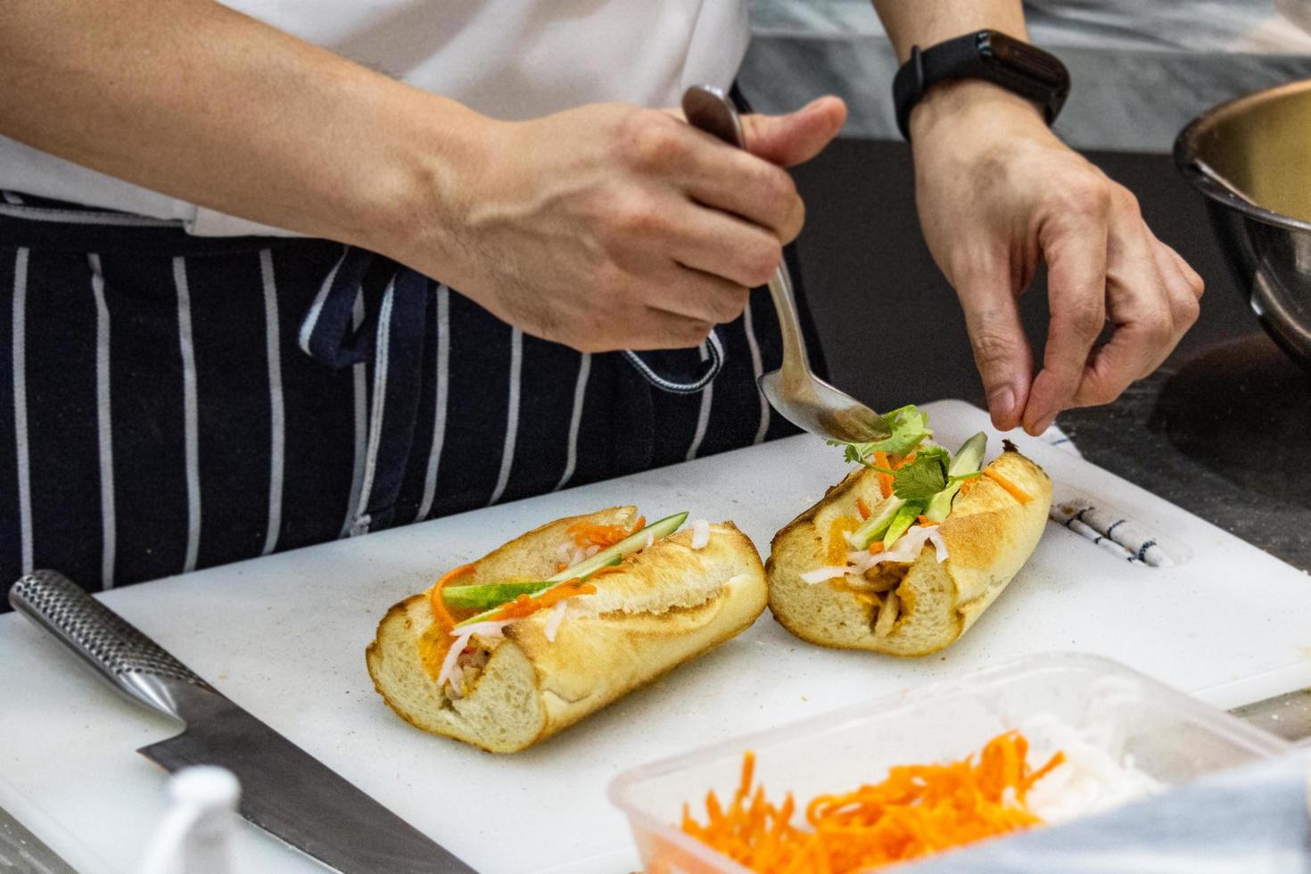 Koch bereitet Sandwich in der Küche zu foto