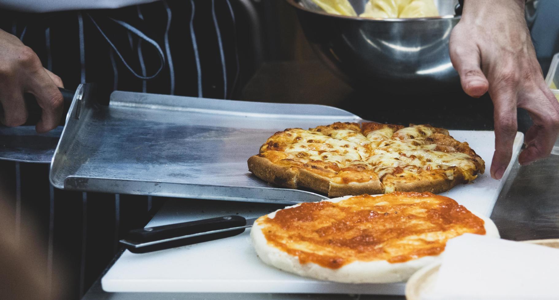 Koch bereitet Pizza zu, der Prozess der Pizzaherstellung foto