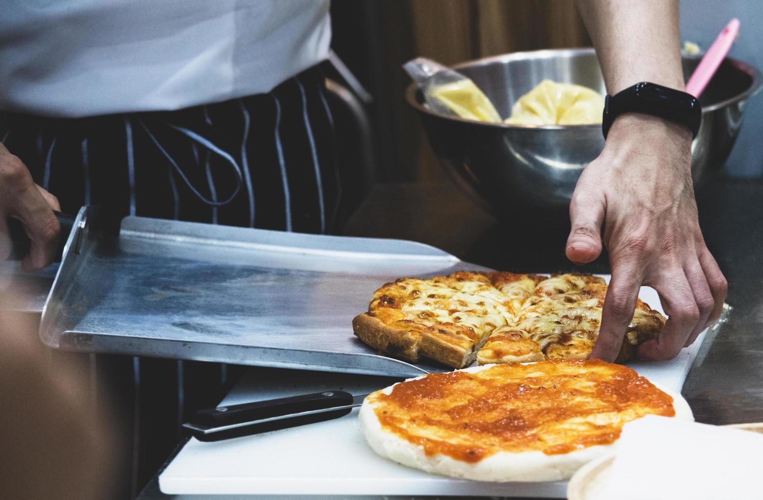 Koch bereitet Pizza zu, der Prozess der Pizzaherstellung foto