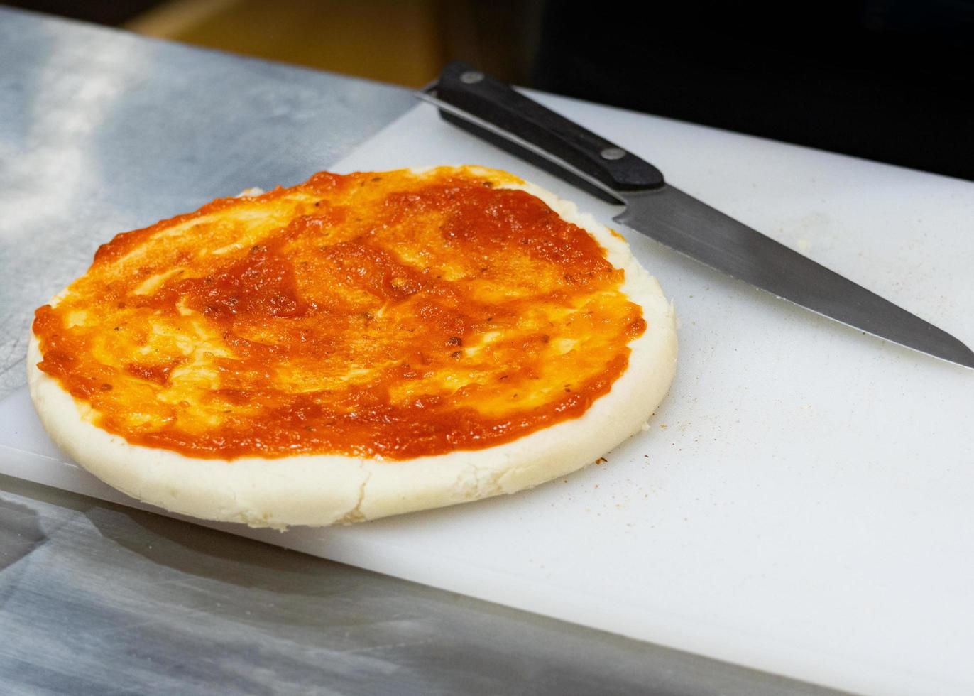 Koch bereitet Pizza zu, der Prozess der Pizzaherstellung foto