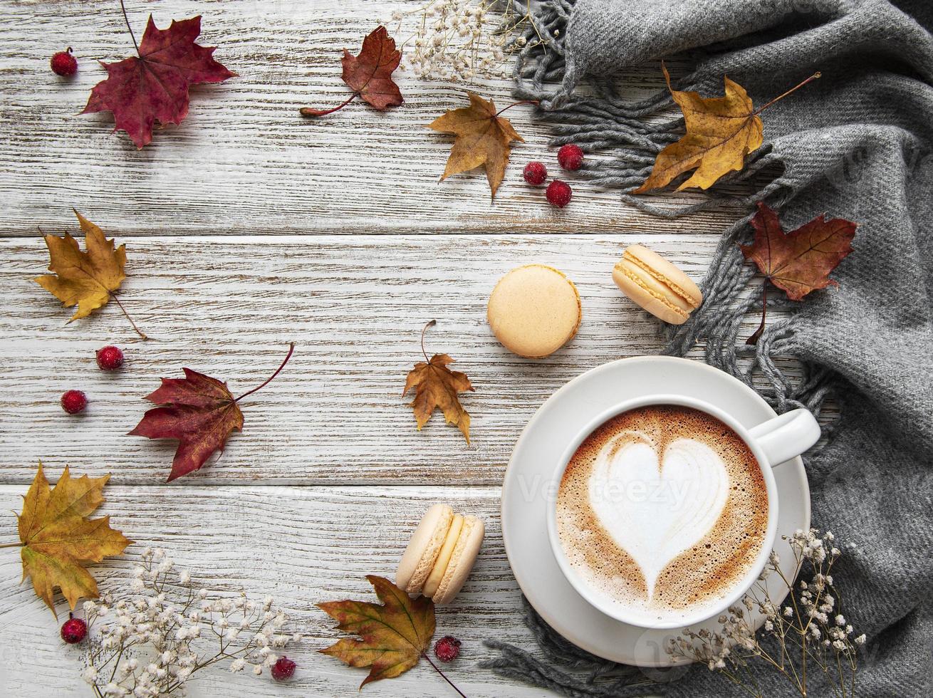 Tasse Kaffee und trockene Blätter auf weißem Holzuntergrund foto