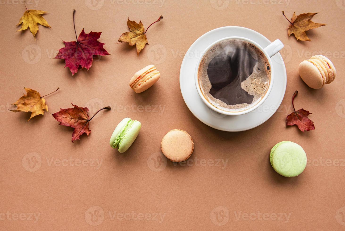 Tasse Kaffee und trockene Blätter auf braunem Hintergrund foto