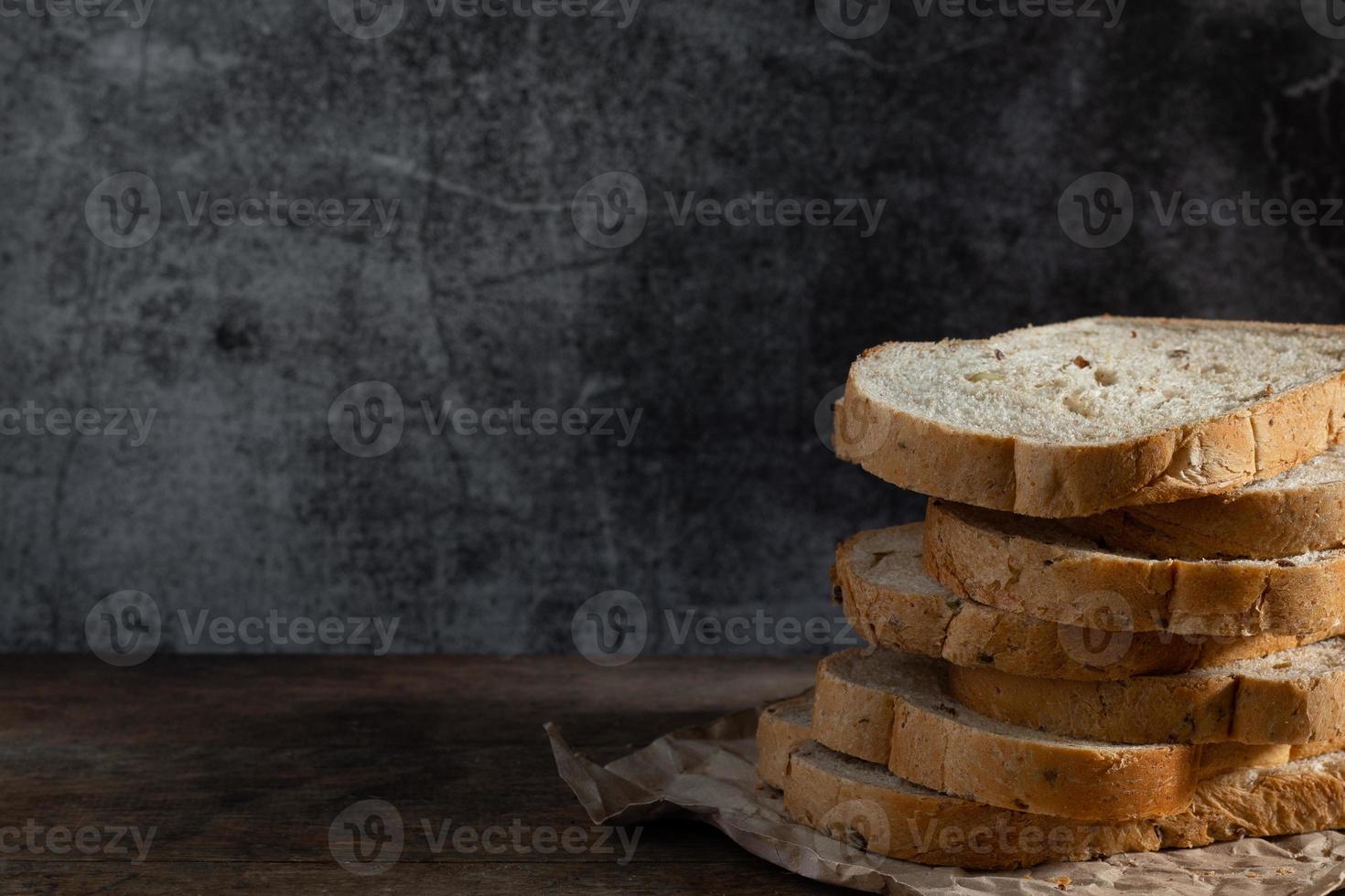 geschnittenes Kornvollkornbrot auf dunklem rustikalem hölzernem Hintergrund foto