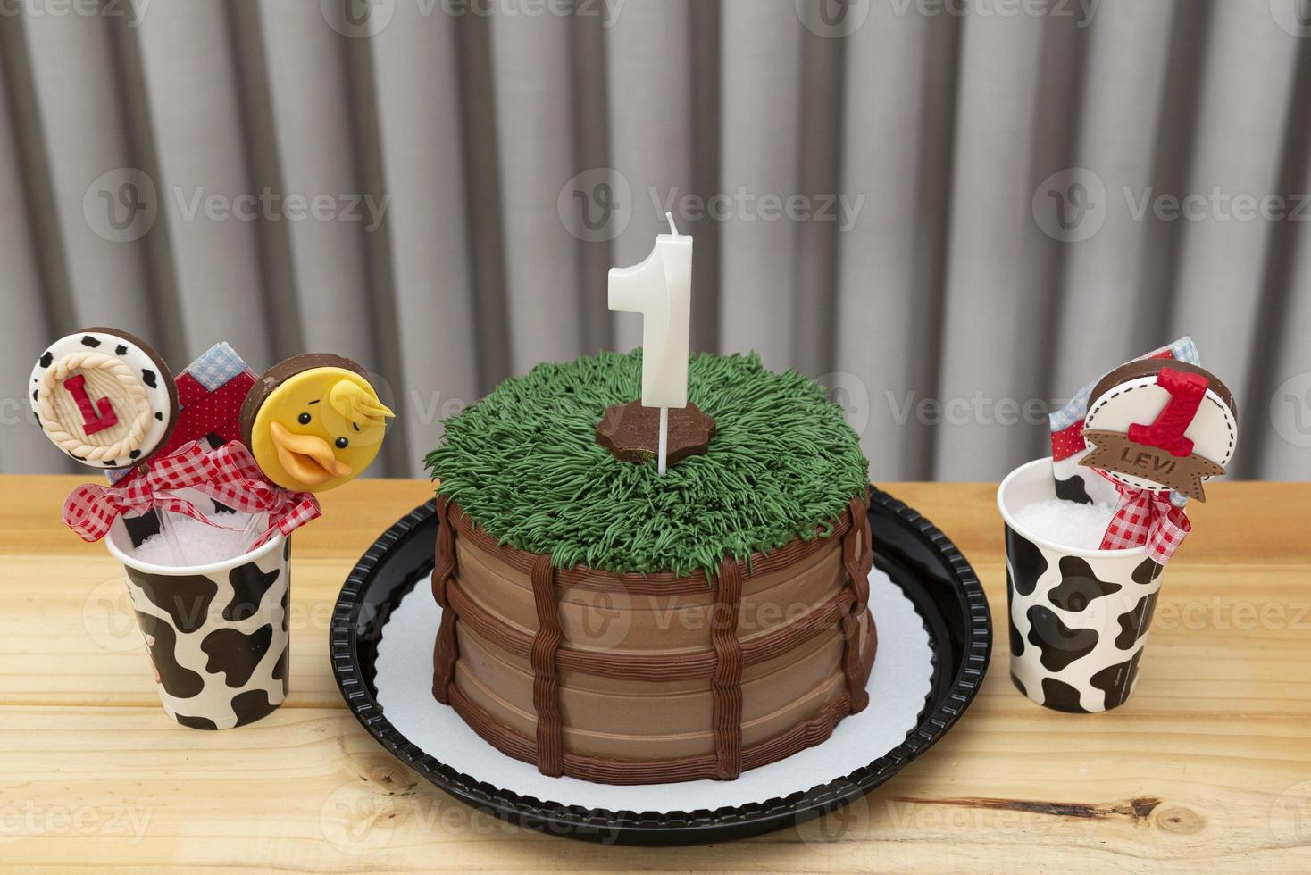 einjährige weiße Kerze auf Kuchen im Landhausstil dekoriert foto