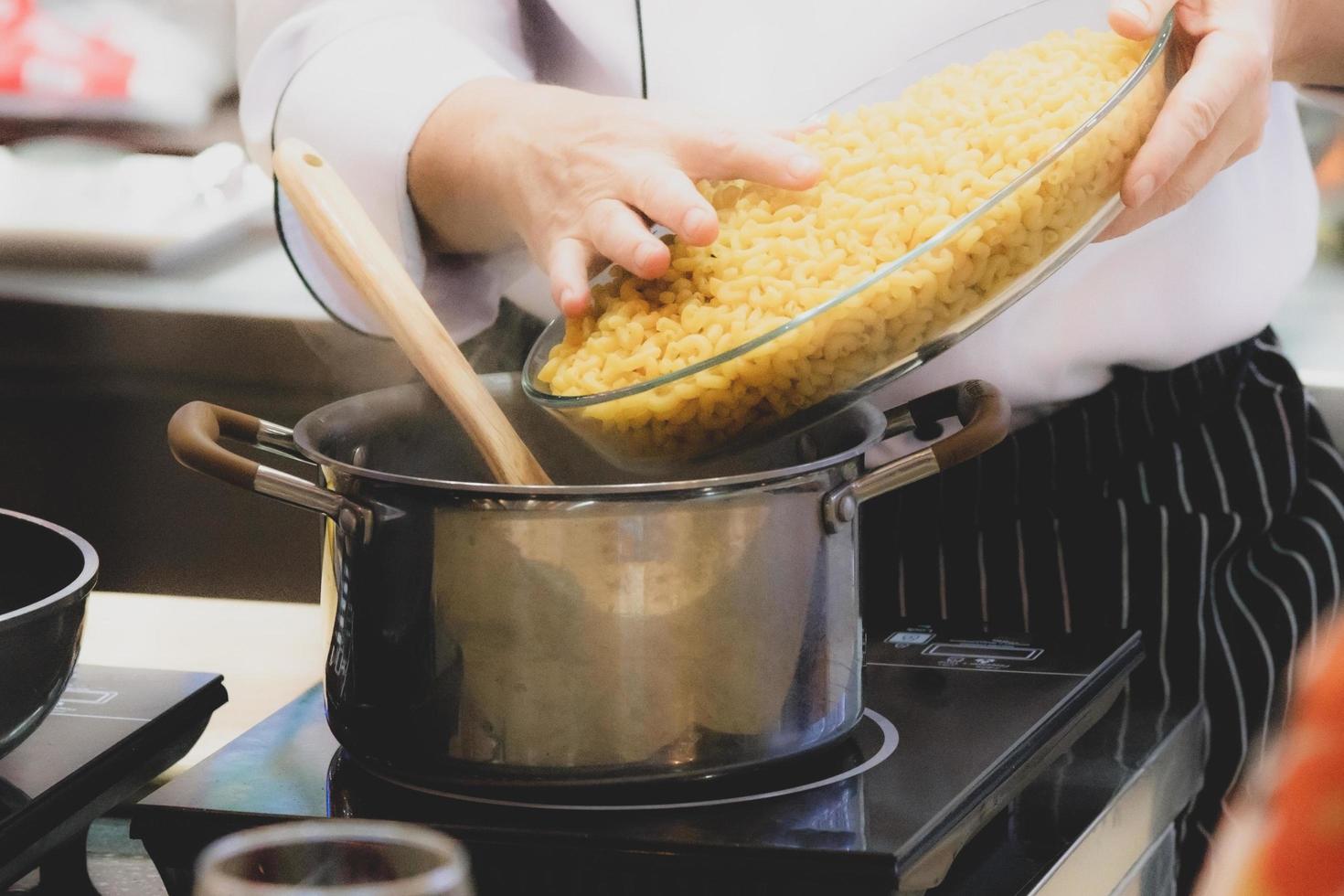 Koch bereitet Essen in der Küche zu, Koch kocht, Koch dekoriert Gericht foto