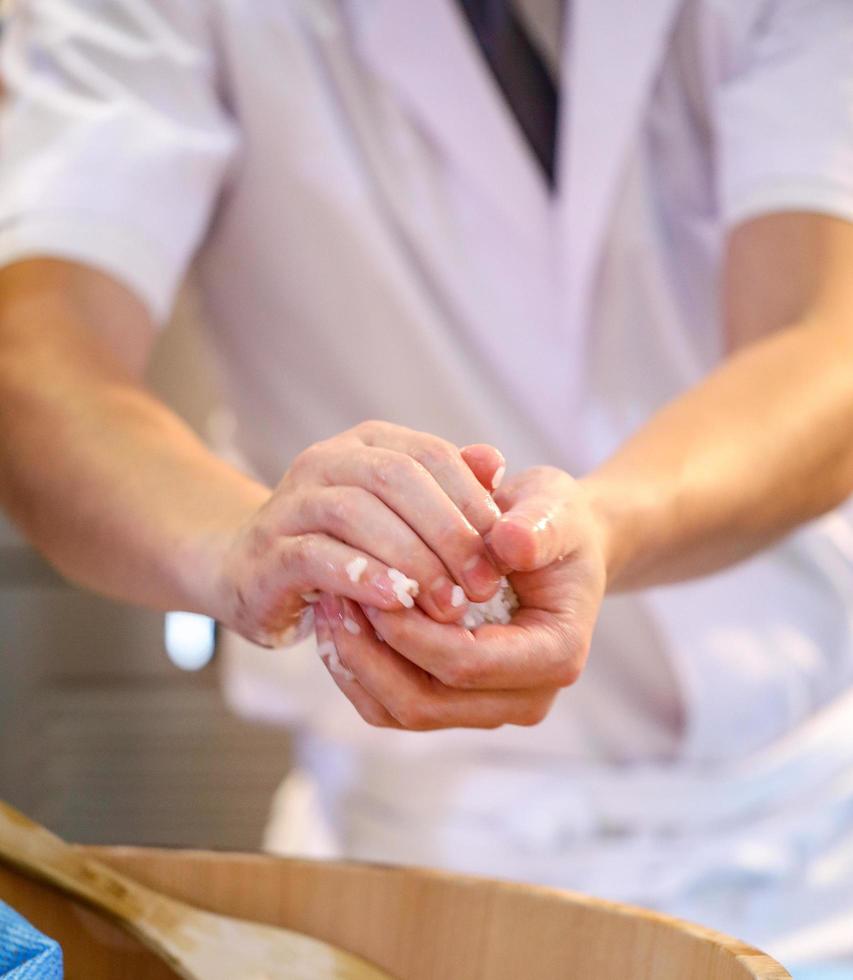 Kochhände bereiten japanisches Essen zu, Koch macht Sushi foto