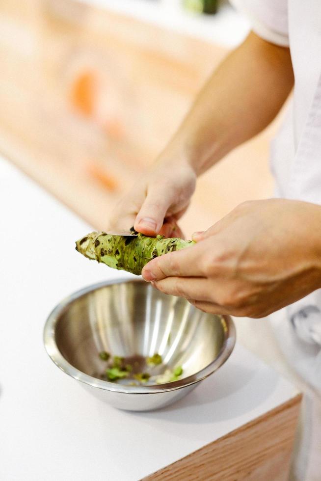 Sushi-Chef reibt frischen Wasabi, frische Wasabi-Wurzel foto