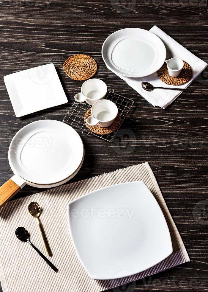 Abendessen auf dunklem Hintergrund, leerer weißer Teller mit Gabel und Löffel foto
