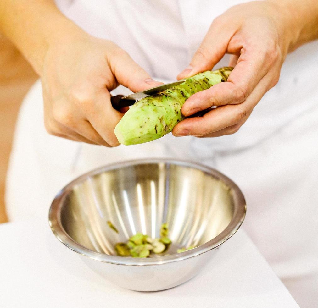 Sushi-Chef reibt frischen Wasabi, frische Wasabi-Wurzel foto