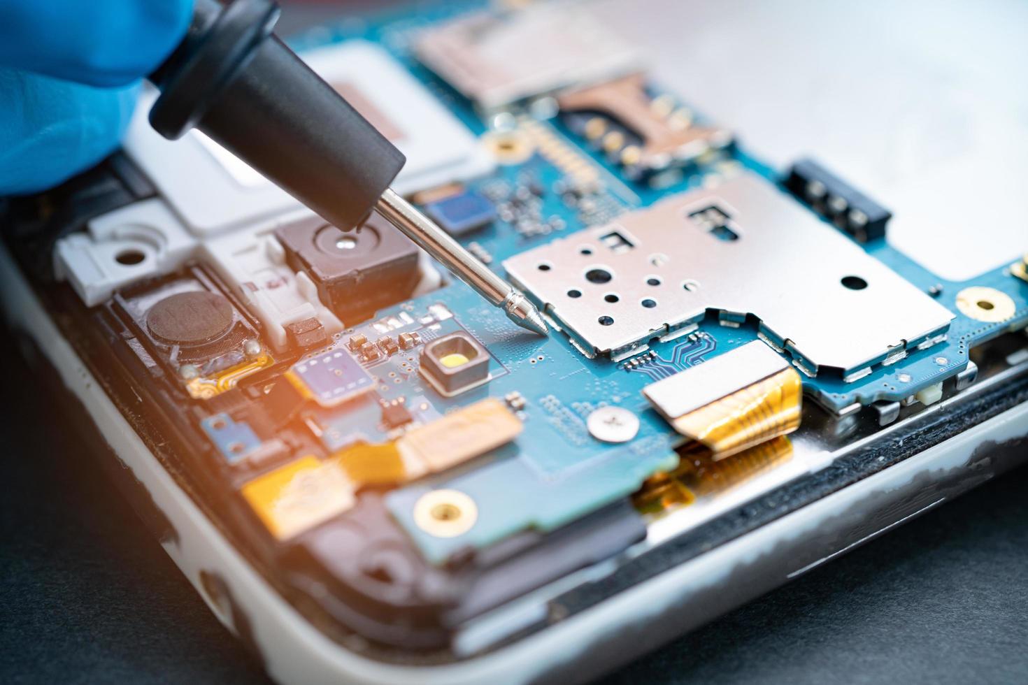 Techniker, der das Innere des Mobiltelefons repariert foto