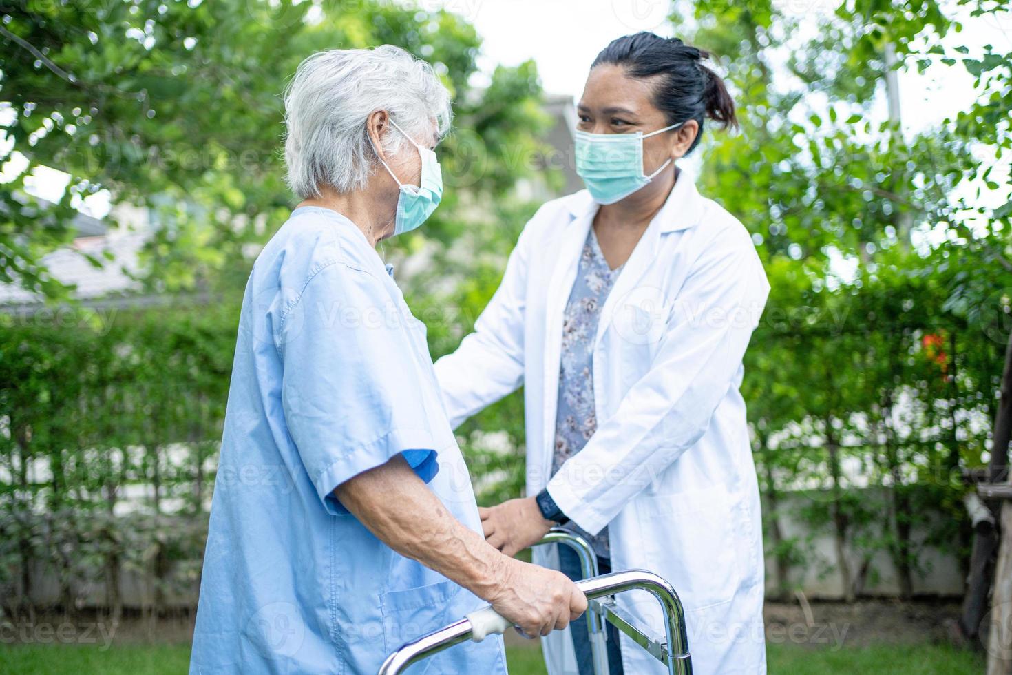 Hilfe und Pflege asiatische Seniorin verwendet Gehhilfe im Park foto