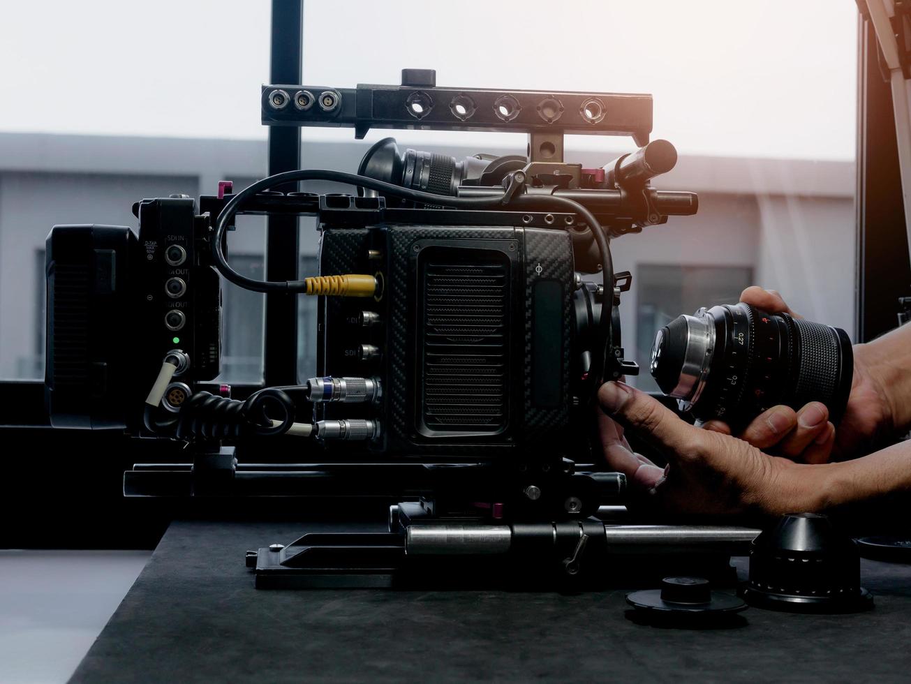 menschliche Hand, die das Kinoobjektiv in eine Filmkamerahalterung einsetzt. foto