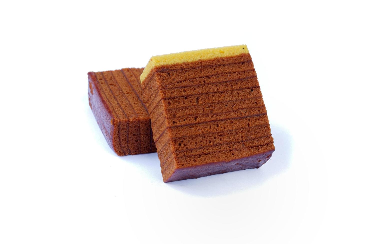 Schokoladen-geschichteter Biskuitkuchen isoliert auf weißem Hintergrund foto