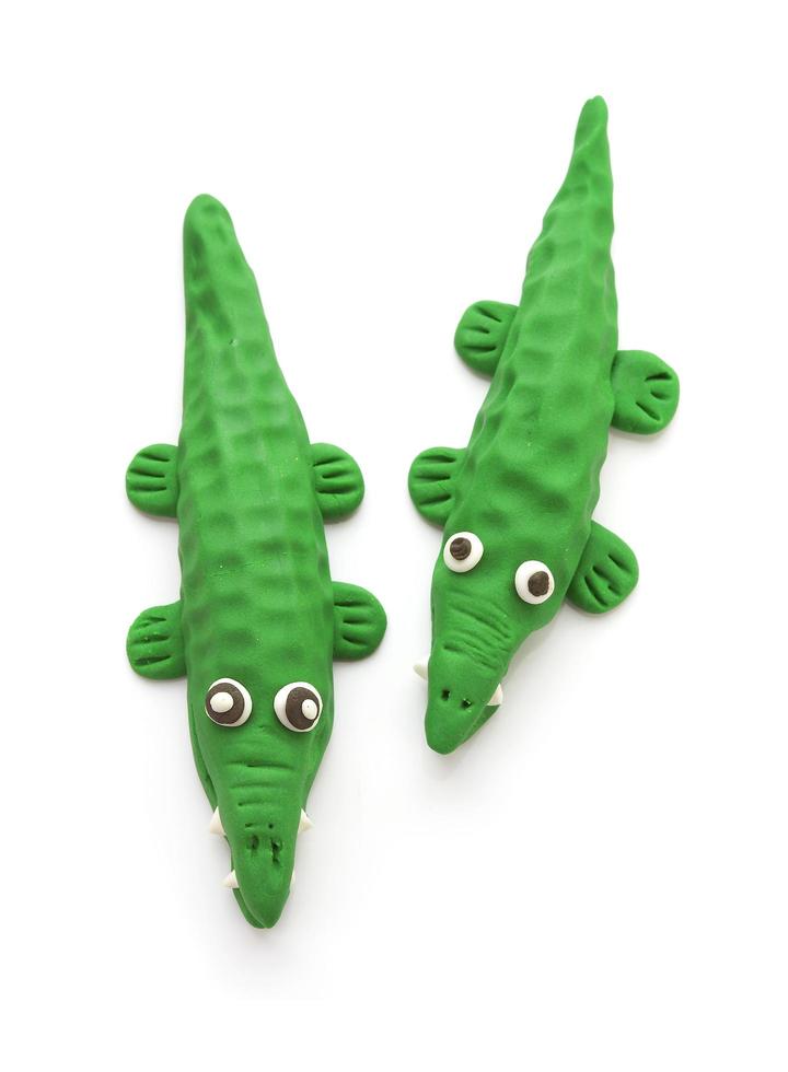 zwei Krokodilpuppen aus Ton auf weißem Hintergrund foto