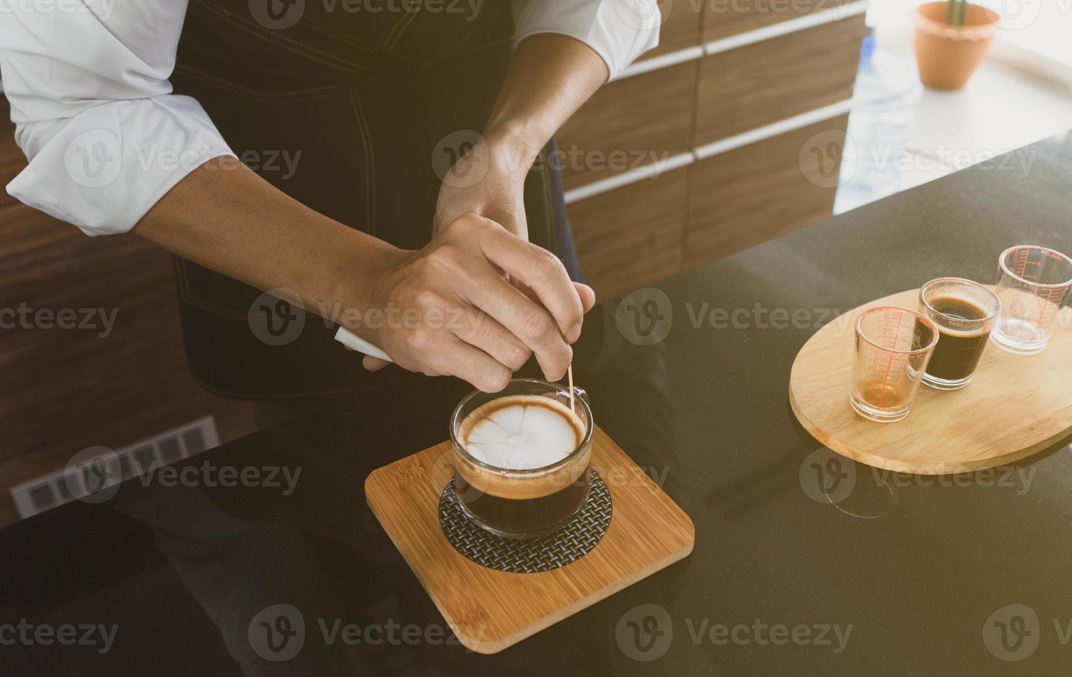 Barista, der Kunstkaffee Latte im Café macht foto