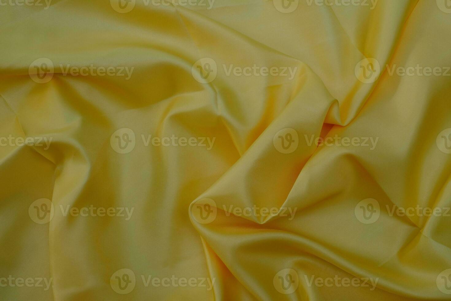 Nahaufnahme der glatten, eleganten gelben Seidenstoff-Luxus-Tuchstruktur foto