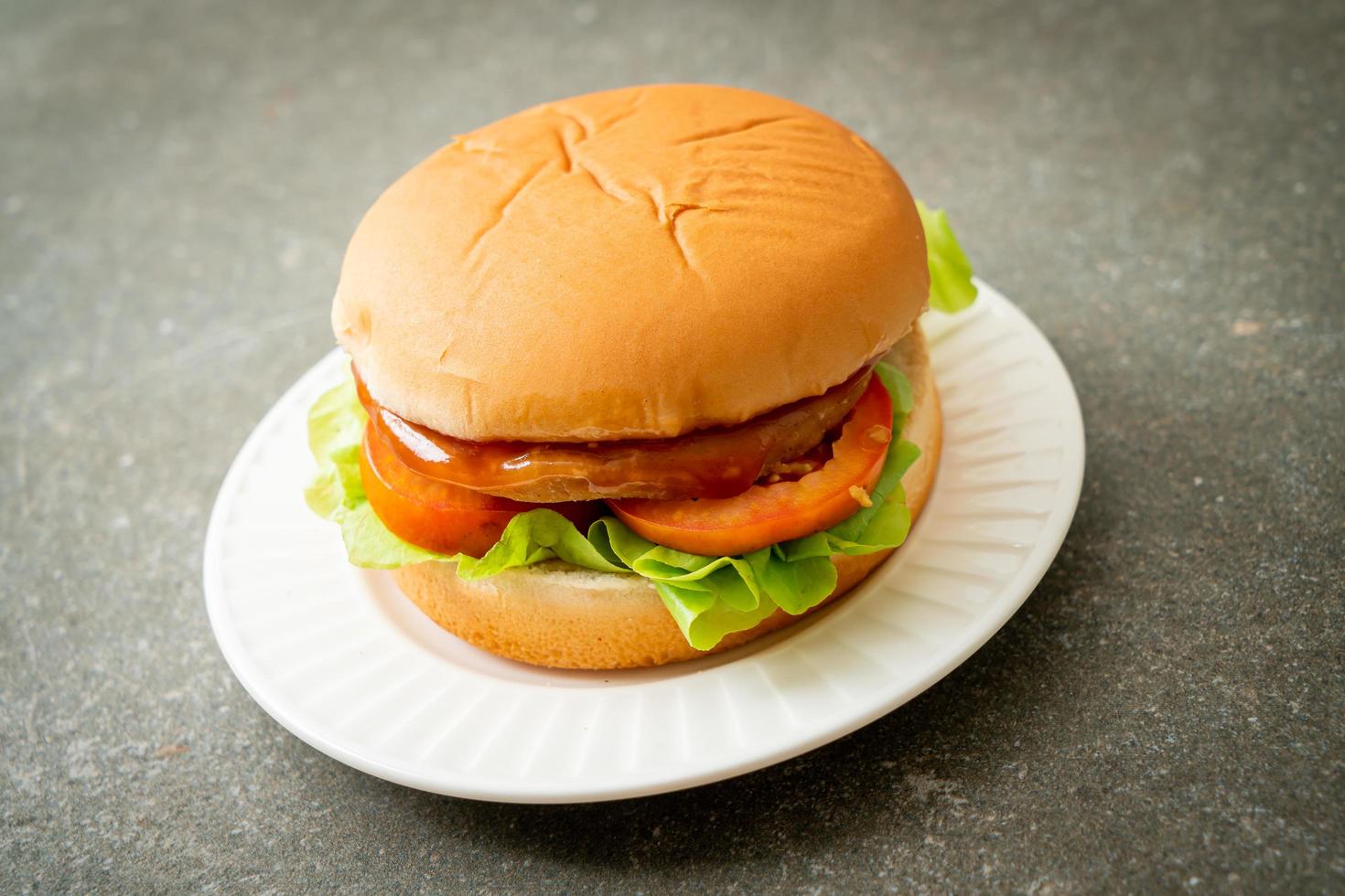 Chicken Burger mit Sauce auf Teller foto