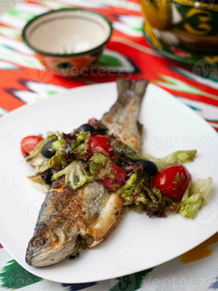 gebraten Fisch mit ein Kissen von gedünstet Gemüse. asiatisch Stil foto